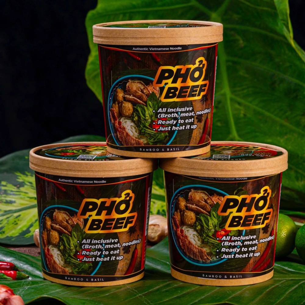 Ba ly Phở Beef BAMBOO & BASIL xếp tháp trên lá xanh, tem thân ôm quanh ly giấy kraft, tem nắp có mã QR